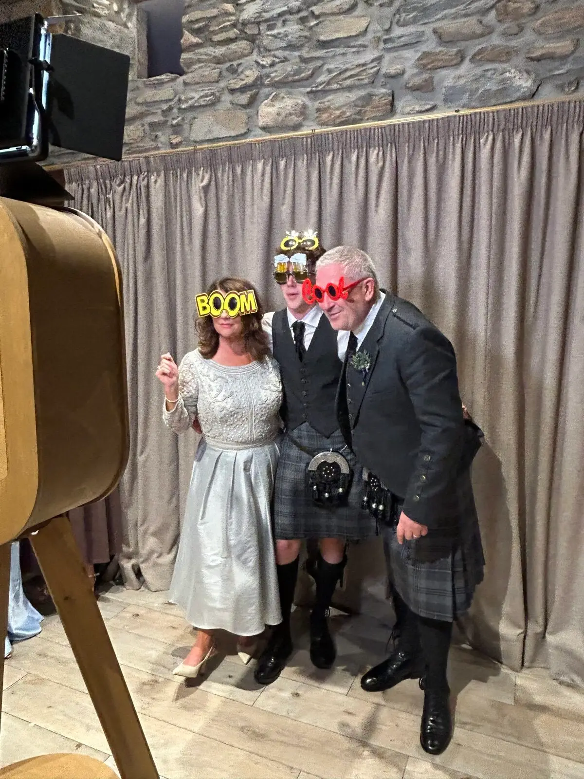 Wedding guests crowded together laughing at a photo booth